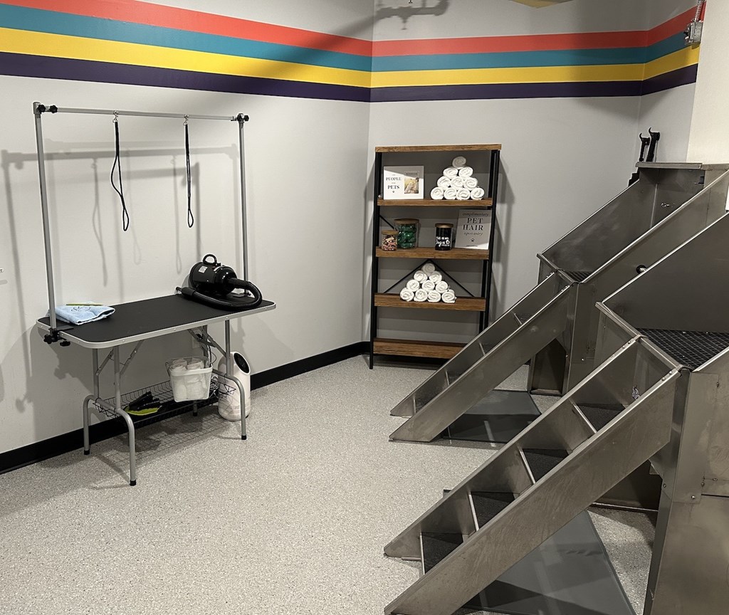 a room with two sets of stairs and a table and a shelf with equipment